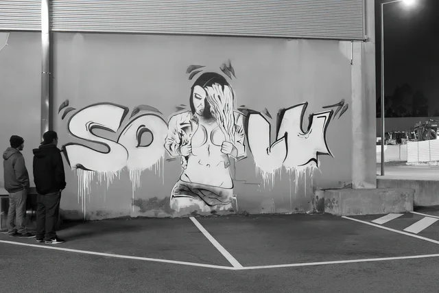 Een zwart-witfiguur verwerkt in een compositie van grote graffitiletters.