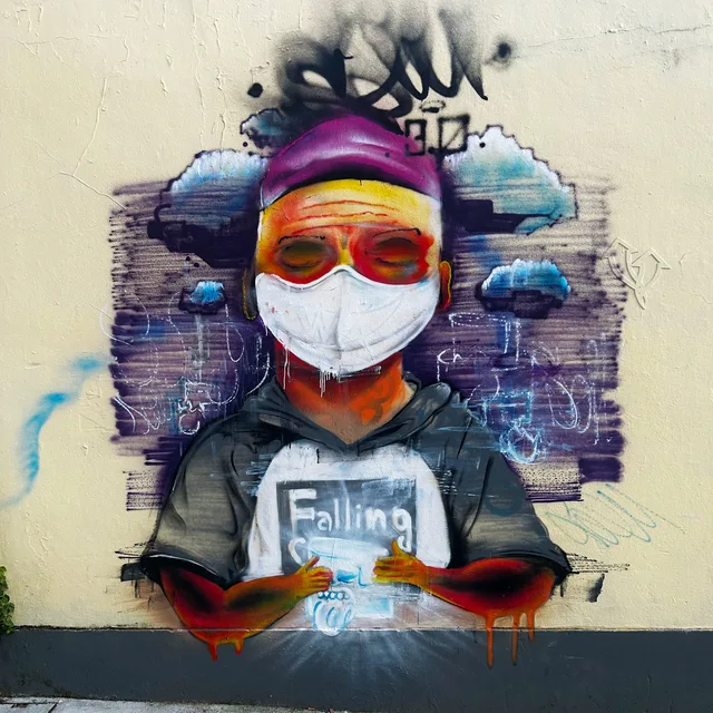 Een figuur met een wit masker en een felle hoofdband, omringd door glitchachtige kleurvlakken en mechanische fragmenten.