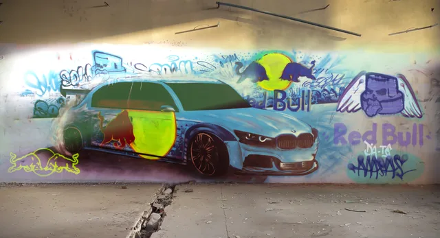 Een auto voor een kleurrijke muurschildering met Red Bull-beeldmerken.